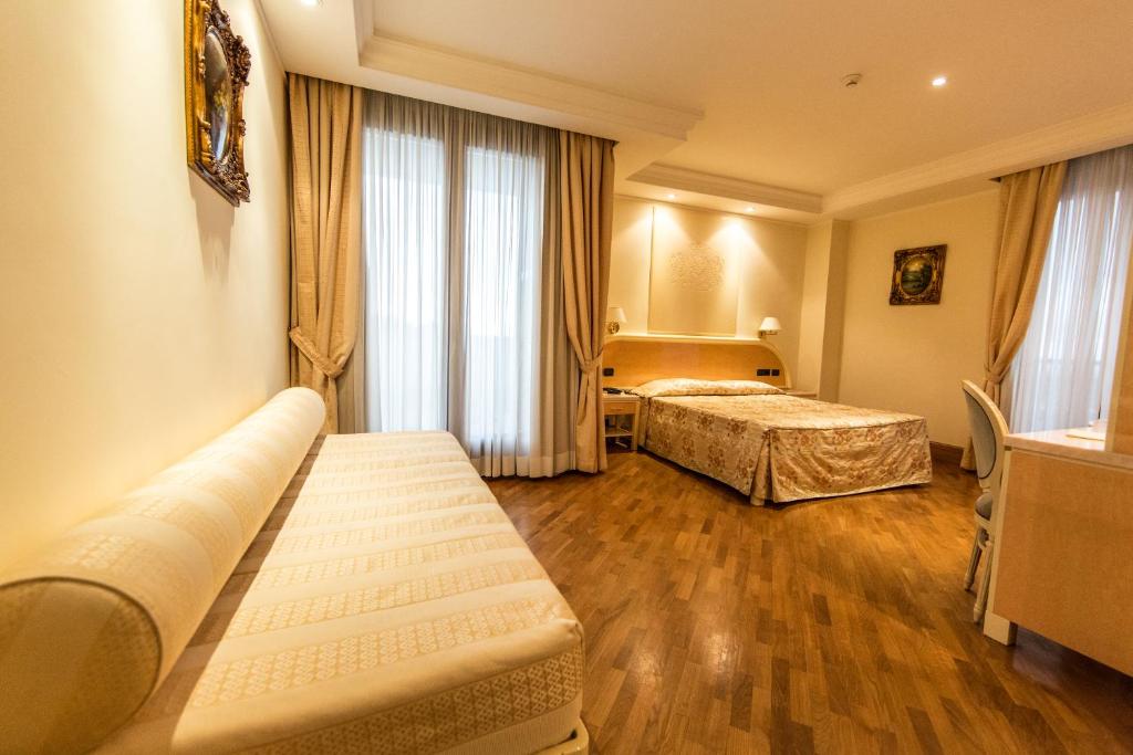 Postel nebo postele na pokoji v ubytování LH Hotel Domus Caesari
