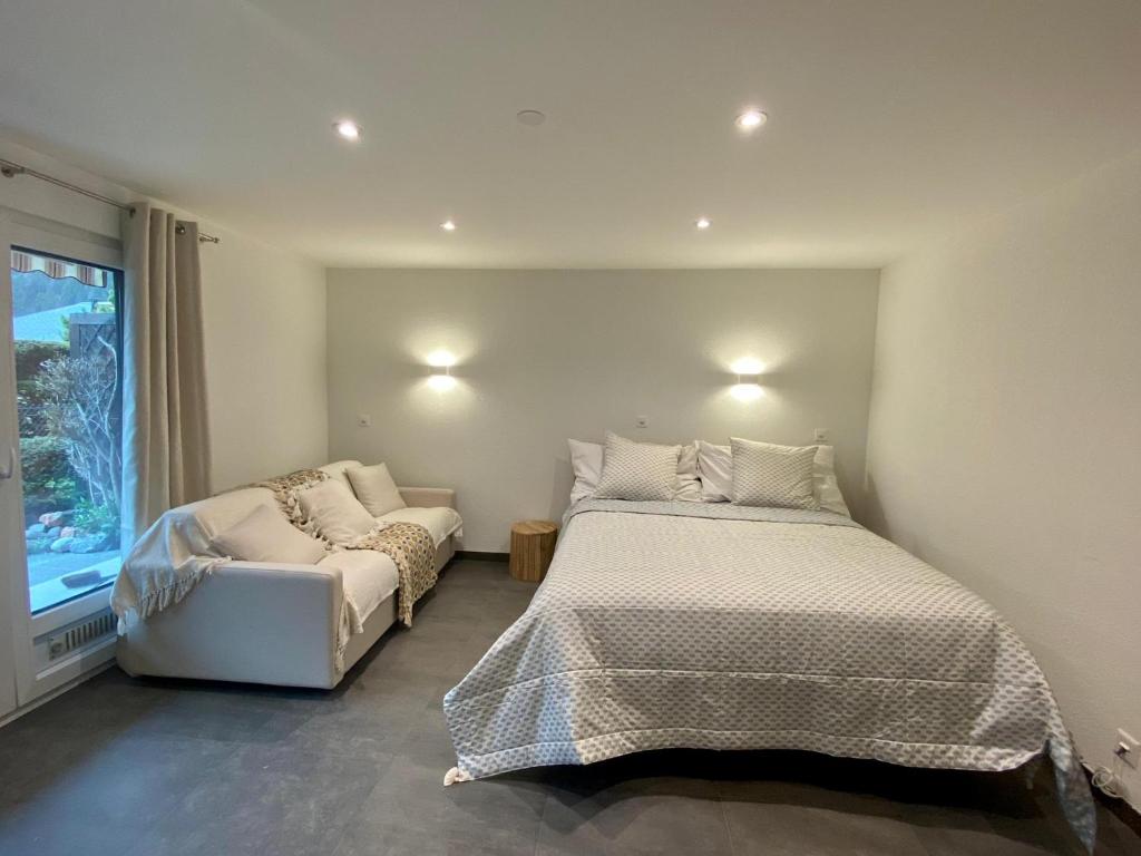 1 dormitorio con cama, sofá y ventana en STUDIO CONFORT & DETENTE en Chesières