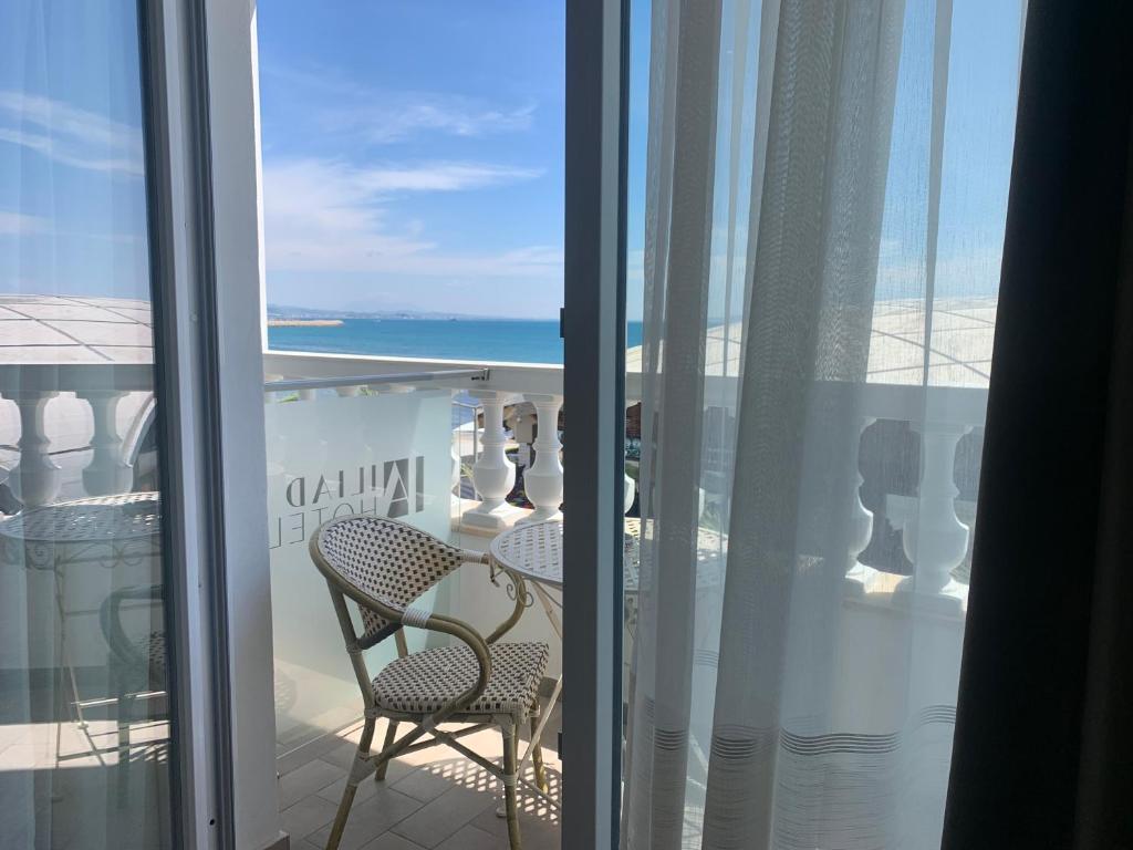 a balcony with a table and chairs and a view of the ocean at Iliad Hotel in Durrës
