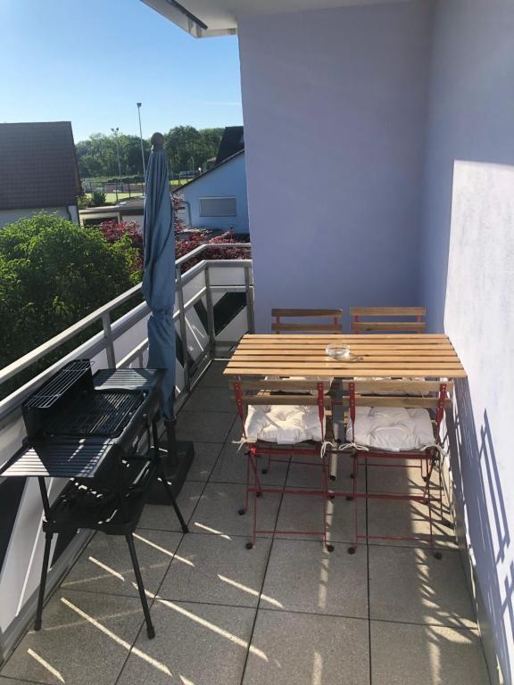 a table and chairs on a balcony with a grill at Eligo in Friedrichshafen