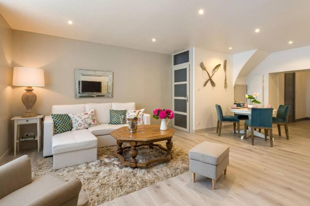 uma sala de estar com um sofá e uma mesa em Chez la Tante Louise - appartement privé de charme em Passenans