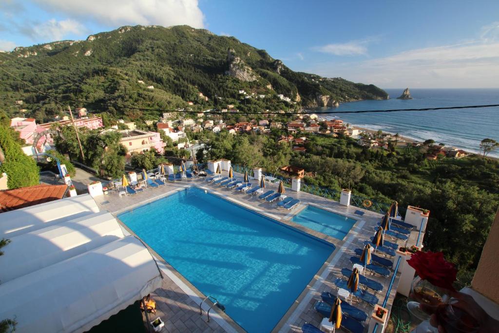 a swimming pool with chairs and a view of the ocean at Lido Sofia Holidays in Agios Gordios