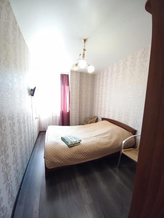 イルクーツクにあるApartament on 30 Deviziiのベッドルーム1室(ベッド1台、椅子付)