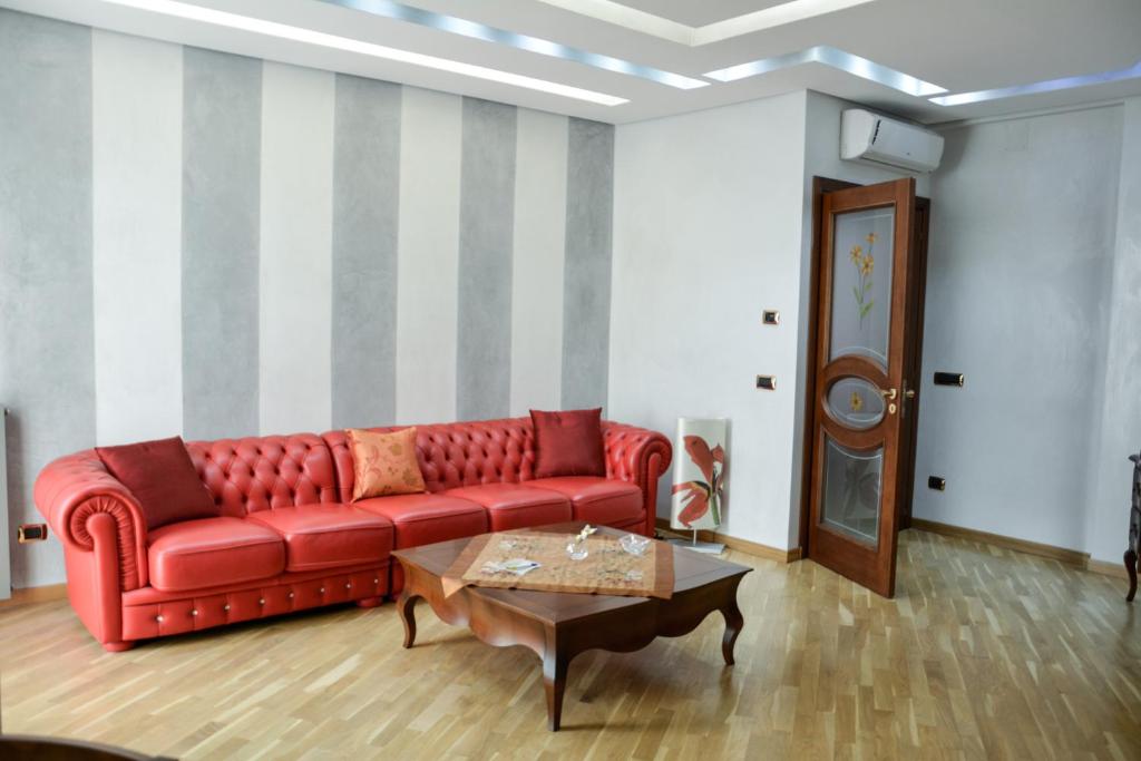 un soggiorno con divano rosso e tavolino da caffè di SGR-OM Luxury House Vatican a Roma