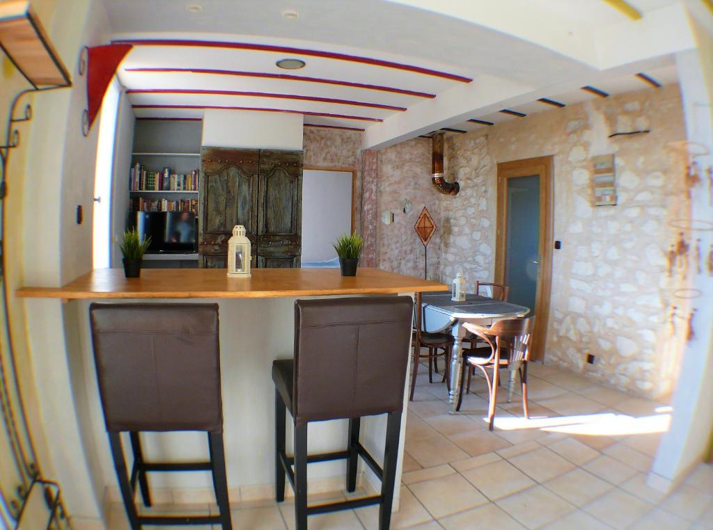een keuken en eetkamer met een aanrecht en stoelen bij Joli appartement à 20 minutes de Montpellier in Vailhauquès