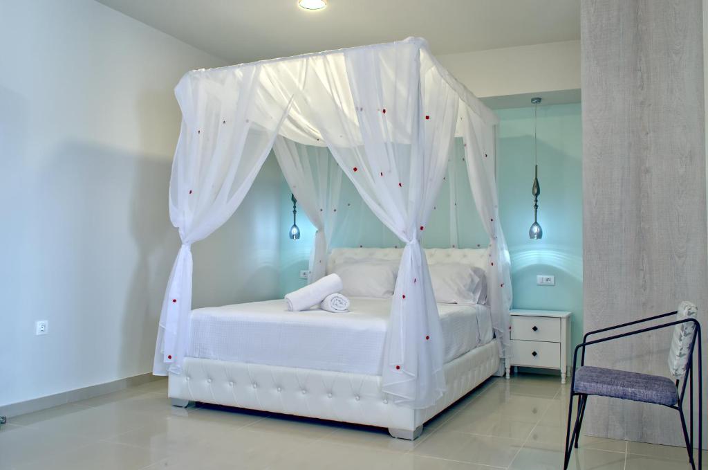 a bedroom with a white bed with a canopy at Epipleon Luxury Suites -101- Δωμάτιο 45τμ με βεράντα 30τμ μπροστά στη θάλασσα in Nafpaktos