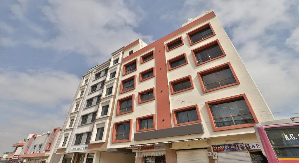 een hoog gebouw met veel ramen aan een straat bij Hotel The Kuber in Dwarka