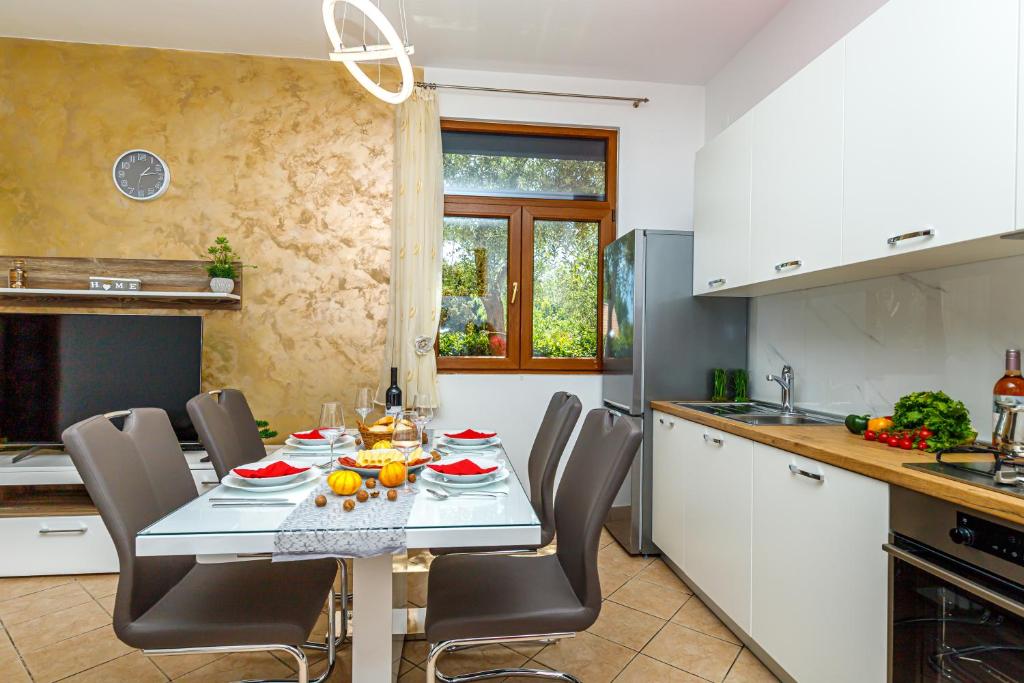 Una cocina con una mesa y sillas en una cocina. en Apartments Kiki 150 METERS TO THE BEACH, en Banjole