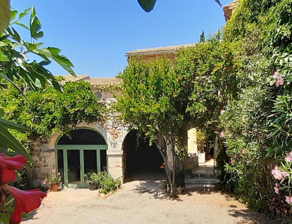 una casa in pietra con un arco in un cortile di Mas Luis Alvarez a La Capelle-et-Masmolène