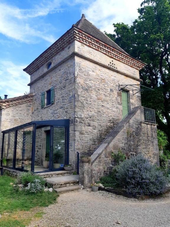 - un vieux bâtiment en pierre avec une porte et une fenêtre dans l'établissement La tourelle 82, à Saint-Antonin