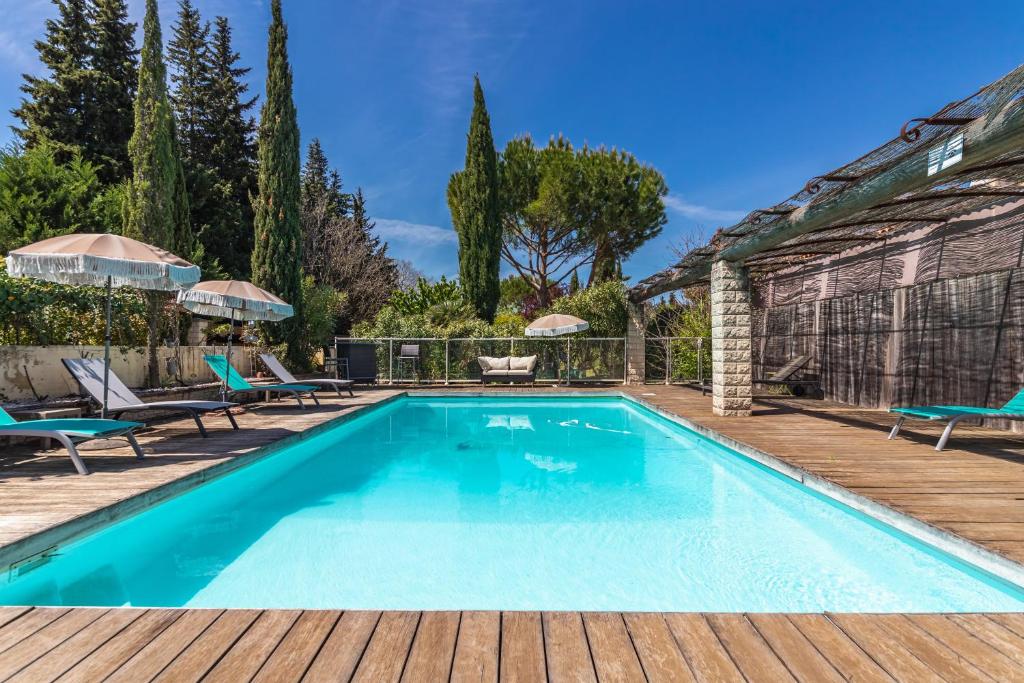 uma piscina com um deque de madeira e uma casa em Jade En Provence em Vaison-la-Romaine