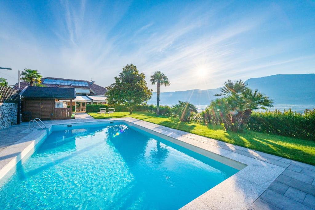 a swimming pool in a yard with a house at Garni Hotel Ritterhof in Termeno