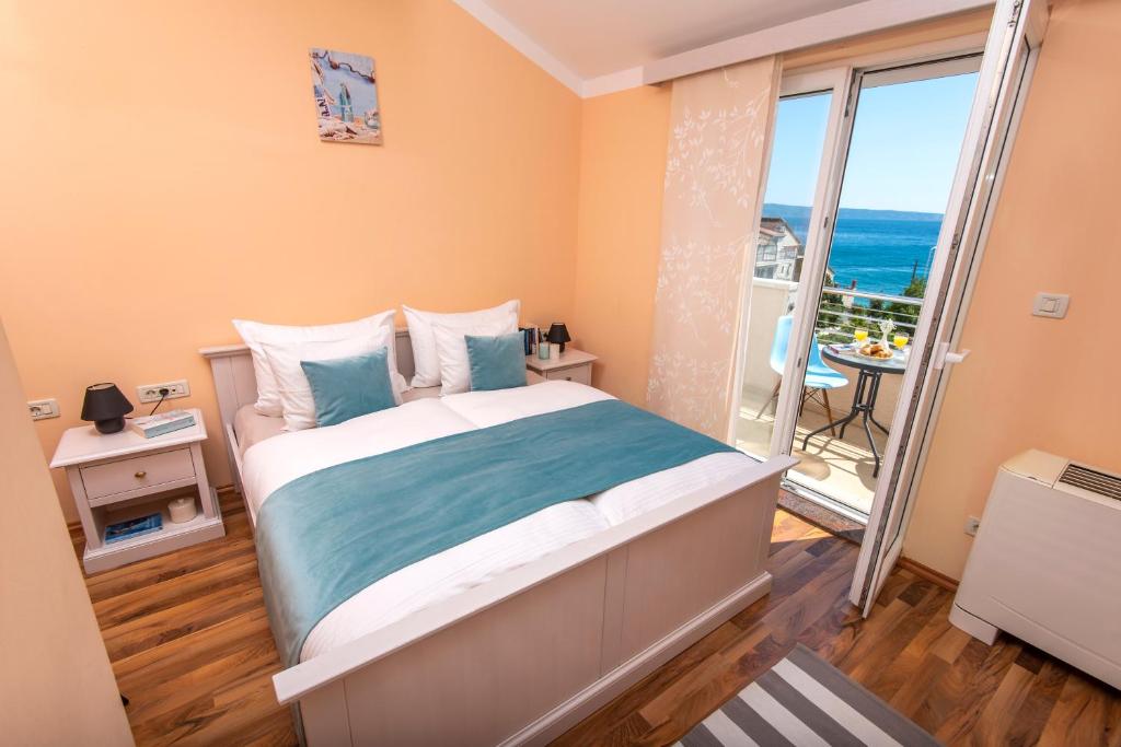 um quarto com uma cama e vista para o oceano em San Marian Apartments em Podstrana