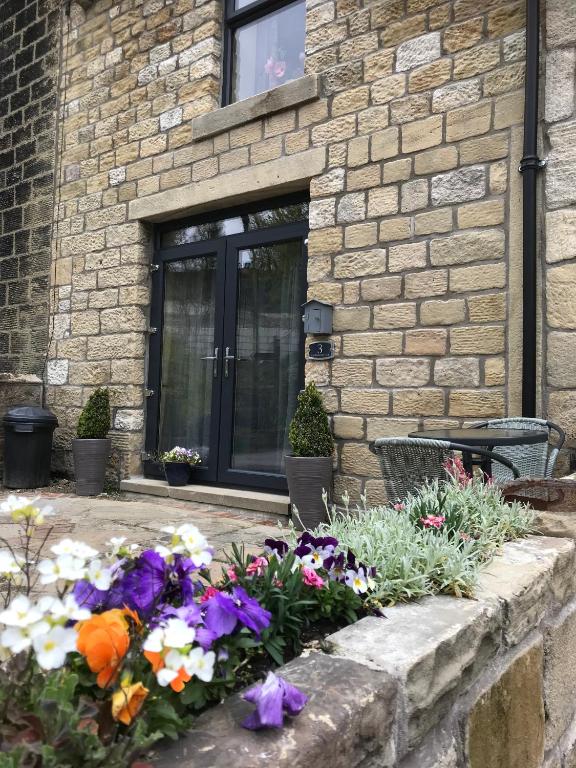 a bunch of flowers in front of a building at Squirrel cottage in Cowling