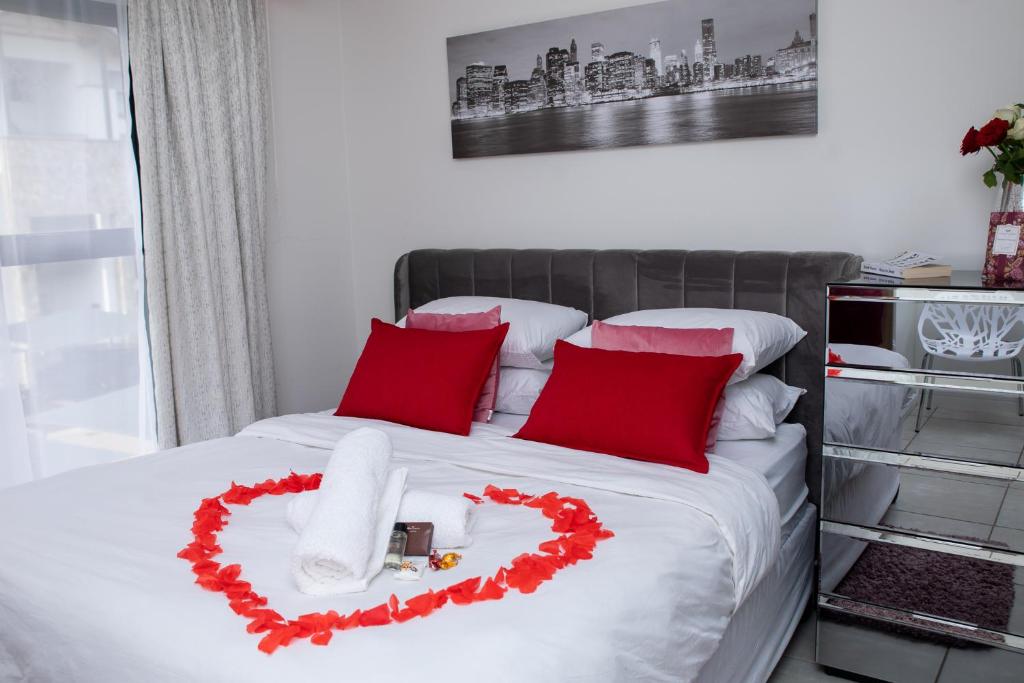 łóżko z sercem wykonanym z czerwonych poduszek w obiekcie The Blyde Riverwalk estate, Crystal Lagoon w mieście Pretoria