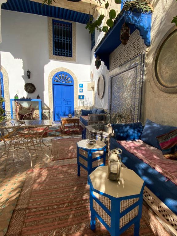 sala de estar con muebles azules y puerta azul en Riad Jean Claude en Fez