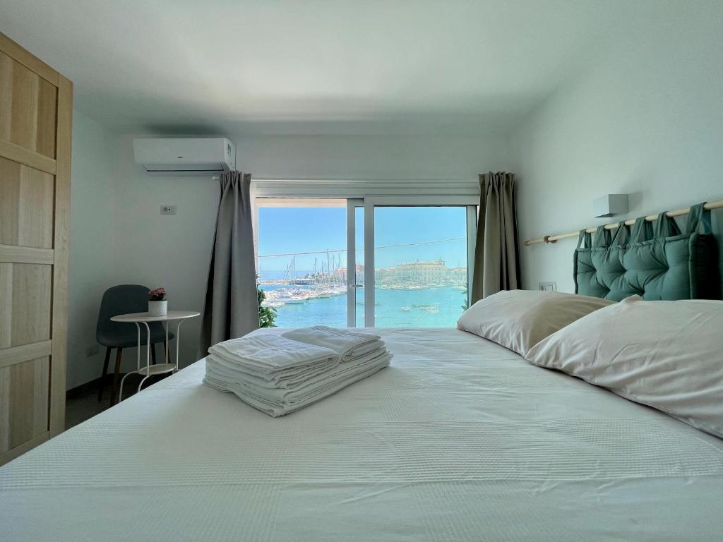 um quarto com uma cama grande e vista para o oceano em Eos Sea View Apartments em Siracusa