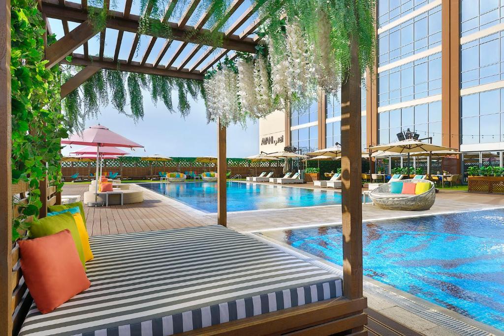 a hotel pool with a bed and a building at Avani Ibn Battuta Dubai Hotel in Dubai