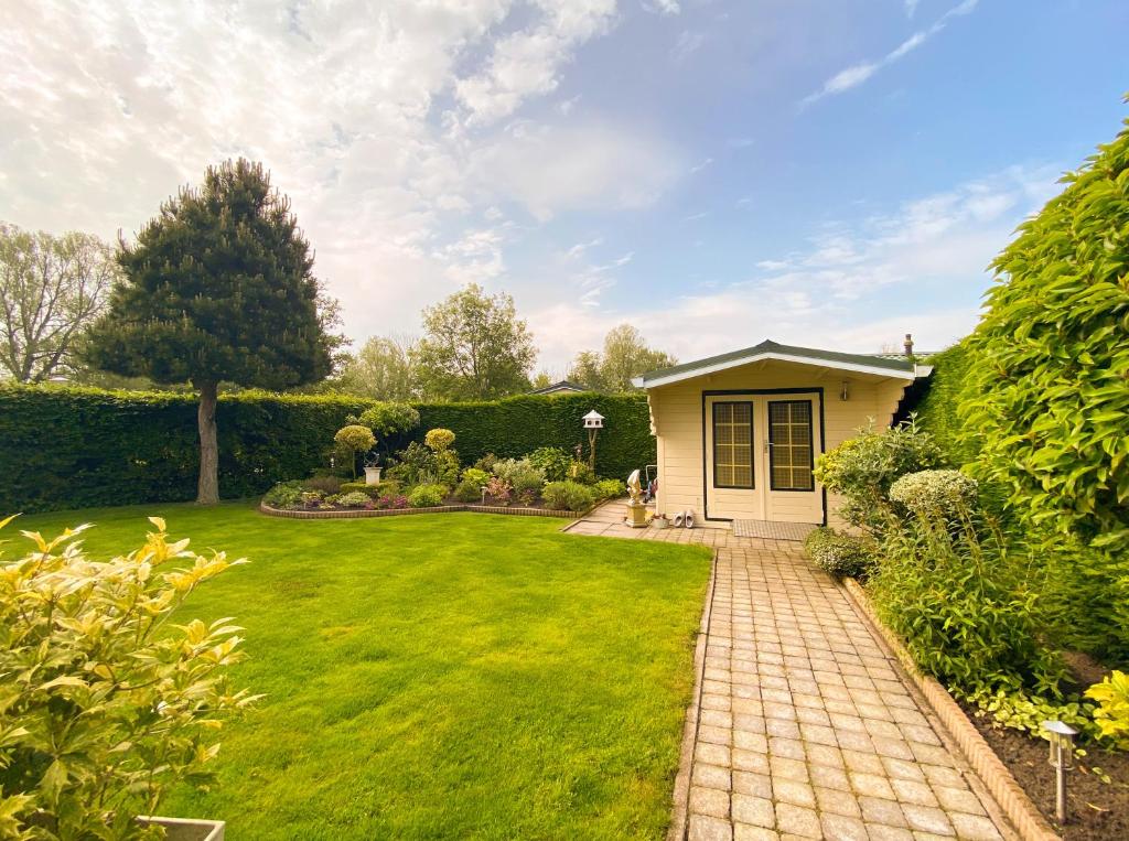 una pequeña casa con una pasarela de ladrillo en un patio en Hello Zeeland - Vakantiehuis Paarlhof 51, en Groede