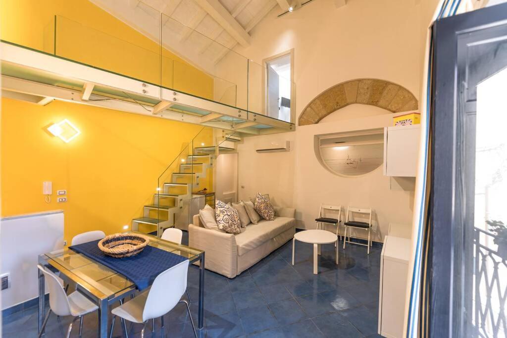 ein Wohnzimmer mit einem Sofa und einem Tisch in der Unterkunft Design loft Marinella in Porticello in Santa Flavia
