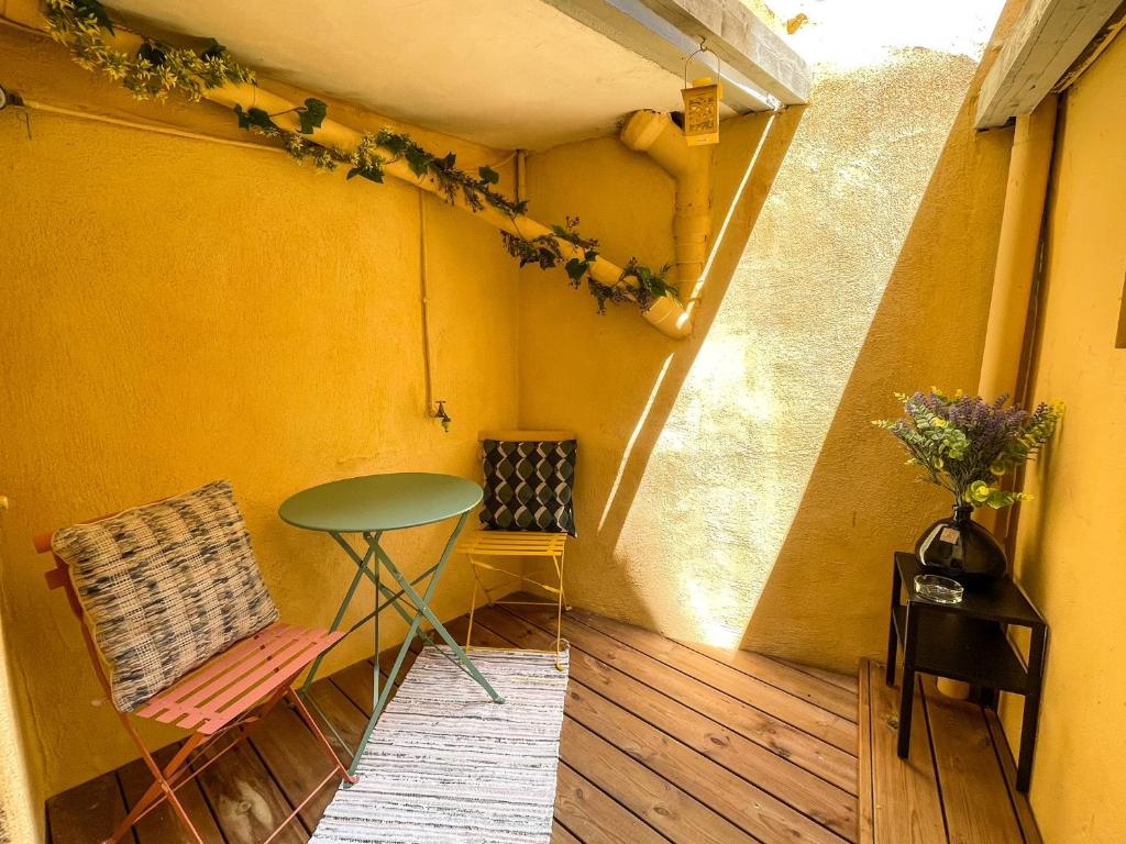 a small balcony with a table and a chair at New! Cosy T2 au coeur de la ville - climatisation - coin terrasse in Aix-en-Provence