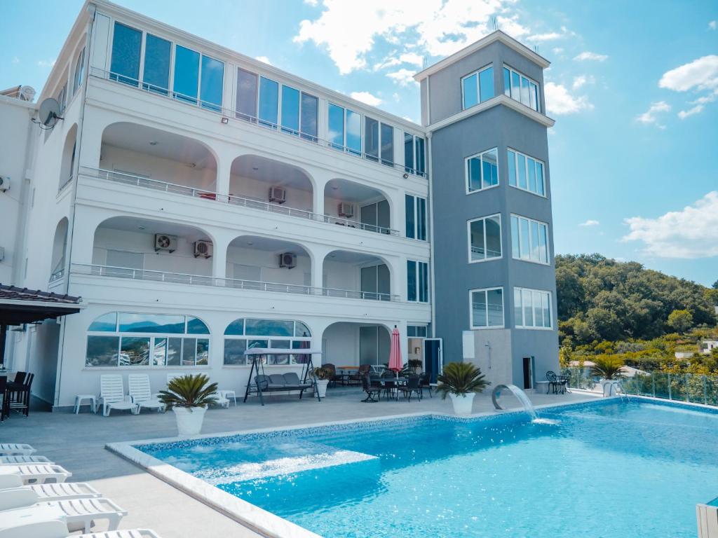 un hotel con piscina al lado de un edificio en Apartments Gjenashaj, en Ulcinj