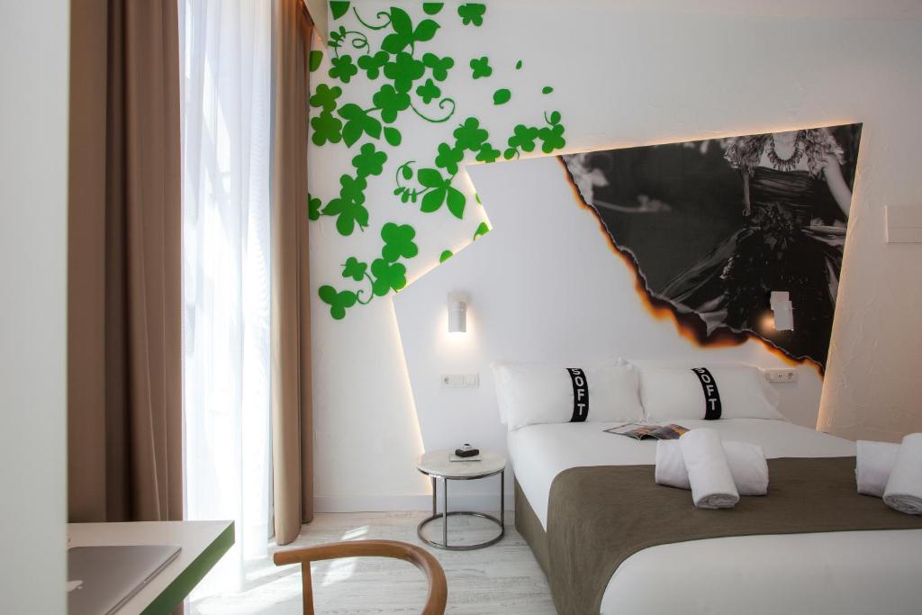 a bedroom with a white bed with a green wall at Casual Socarrat Valencia - Adults Only in Valencia