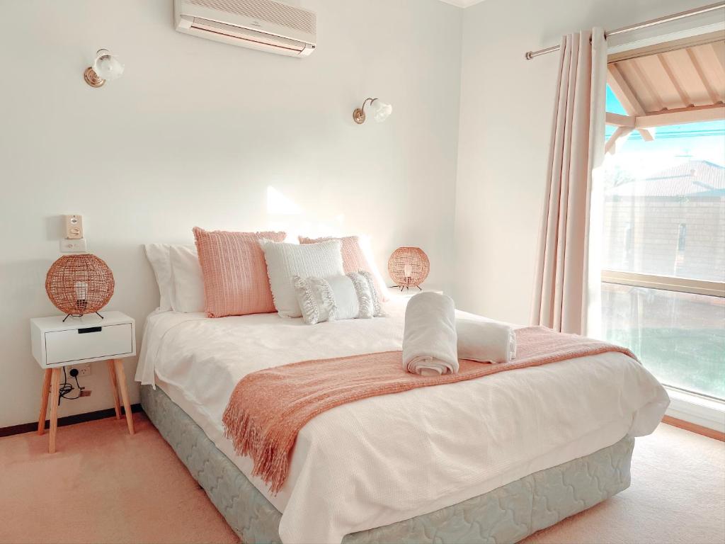 biała sypialnia z dużym łóżkiem i oknem w obiekcie Carnarvon 3BR & 2BA Holiday House w mieście Carnarvon