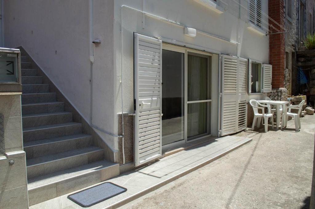 um edifício com escadas, uma mesa e cadeiras em Apartman Marijela em Vela Luka