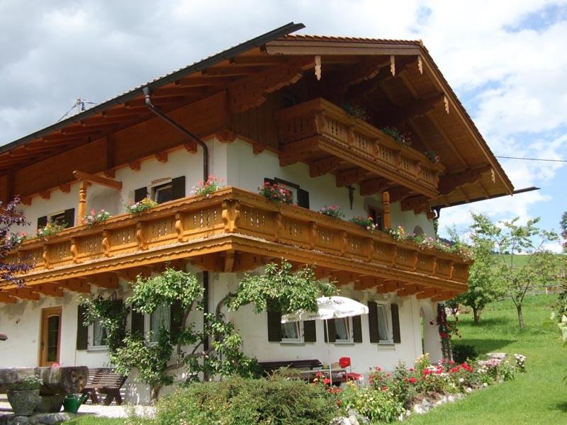 une maison avec un balcon au-dessus dans l'établissement Ferienwohnungen Oberthannlehen, à Bischofswiesen