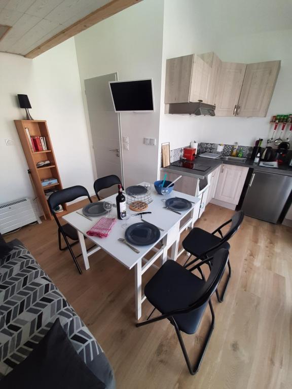 - une cuisine avec une table et des chaises dans la chambre dans l'établissement Studio neuf proche Océan, à La Rochelle