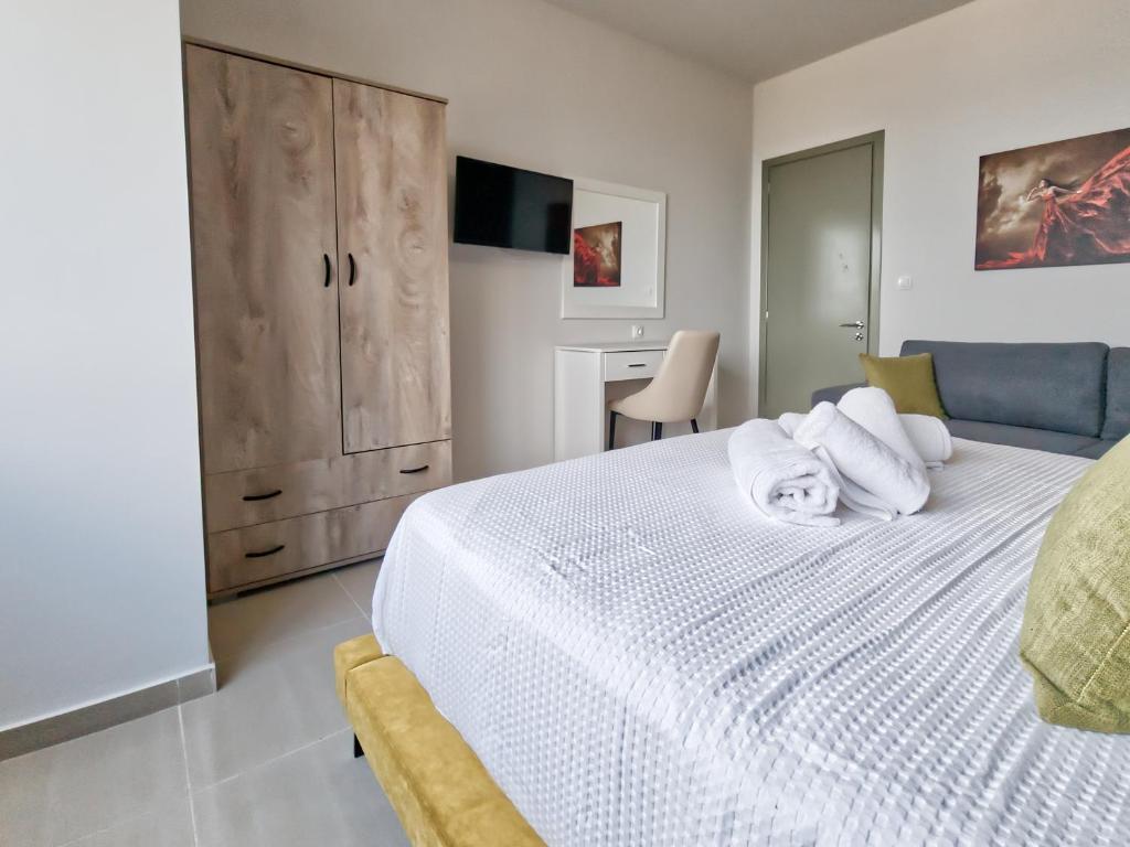 - une chambre avec un grand lit blanc et un bureau dans l'établissement Epipleon Luxury Suites - 107 - Διαμέρισμα 85τμ - Θέα στη θάλασσα, à Naupacte