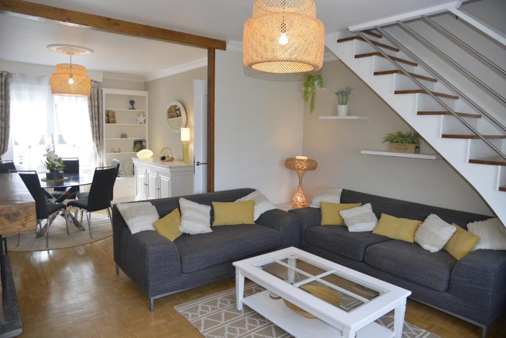 een woonkamer met een bank en een trap bij Céleste In in Port-Louis