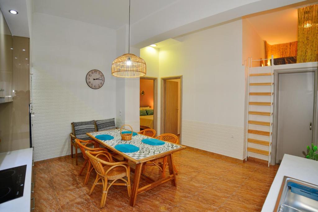 Mpoulakis Apartment 46 في كيساموس: غرفة طعام مع طاولة وكراسي وساعة