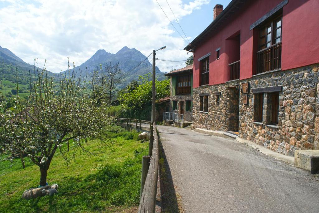 eine leere Straße neben einem Gebäude mit Bergen im Hintergrund in der Unterkunft Mirador del Oso in Proaza