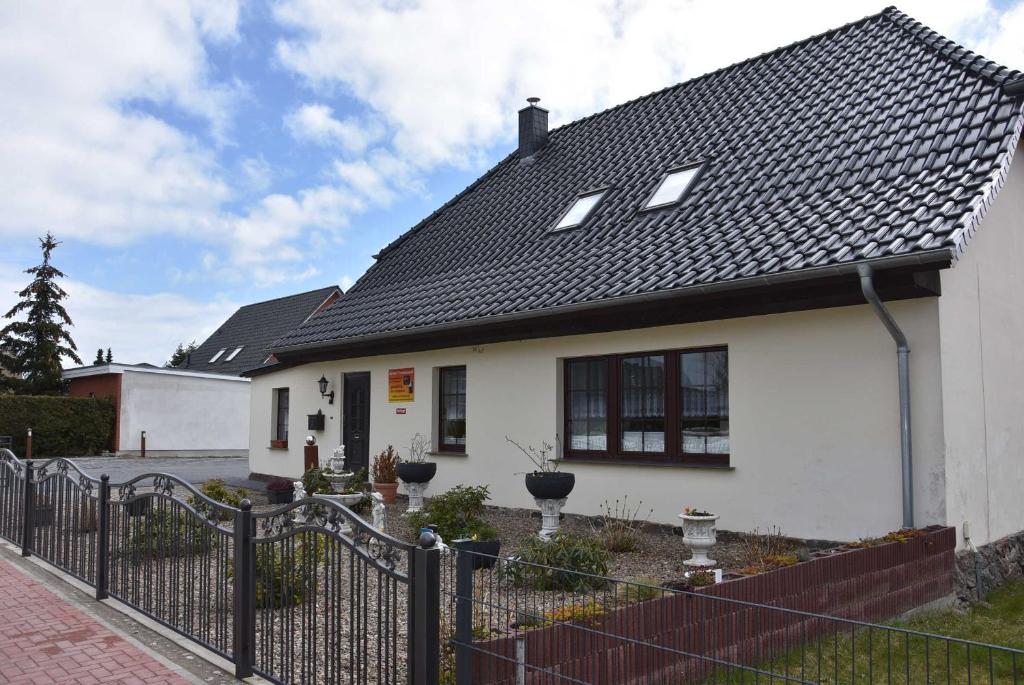 ein weißes Haus mit einem schwarzen Dach in der Unterkunft Karlshagen - Lissis Feriendomizil in Ostseebad Karlshagen