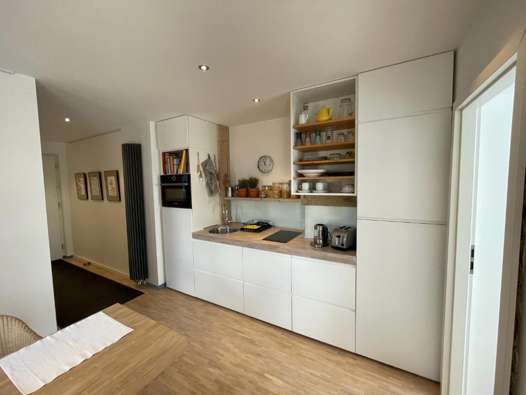 
a kitchen with white cabinets and white appliances at Wohnen auf Zeit, Boardinghouse-Oelde, Ost, West, Süd in Oelde
