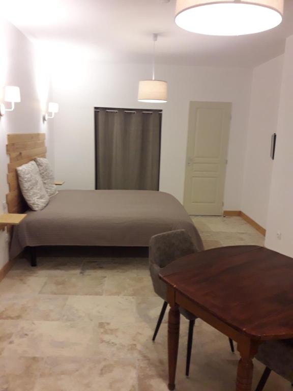 a bedroom with a bed and a table in it at La Maison d Antoine in Tarascon-sur-Ariège