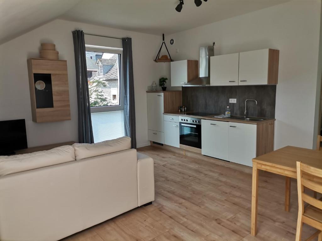 salon z białą kanapą i kuchnią w obiekcie Sonnenufer Apartment & Moselwein I w mieście Bernkastel-Kues