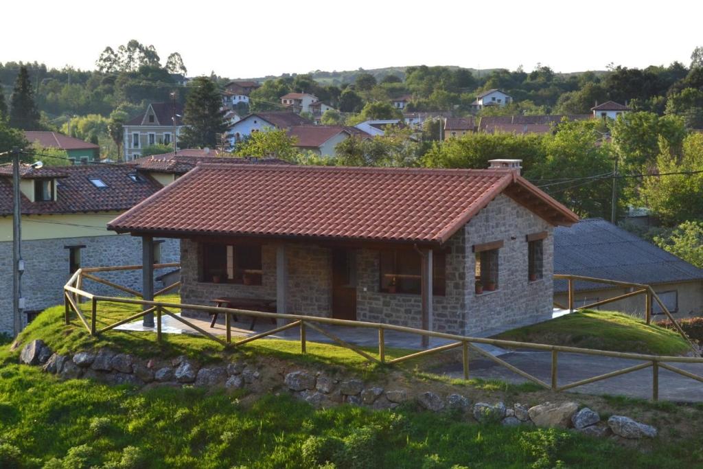 une petite maison en pierre avec un toit rouge dans l'établissement Ruiloba II, à Ribadesella