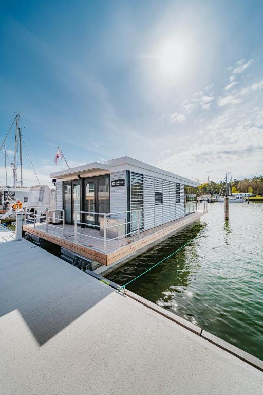 a house on a dock on a body of water at Schwimmendes Ferienhaus "Trinity" Ihr Seahome auf der Ostsee in Peenemünde
