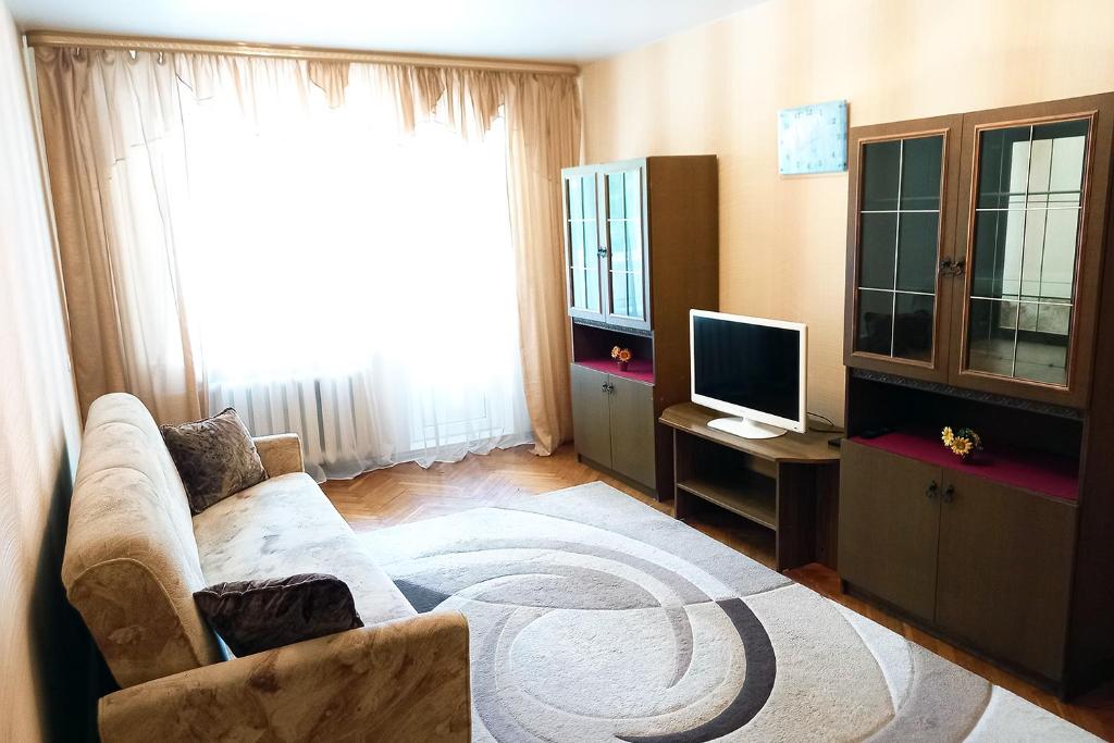a living room with a couch and a television at Уютная, благоустроенная 2-комнатная квартира, WiFi in Bobruisk