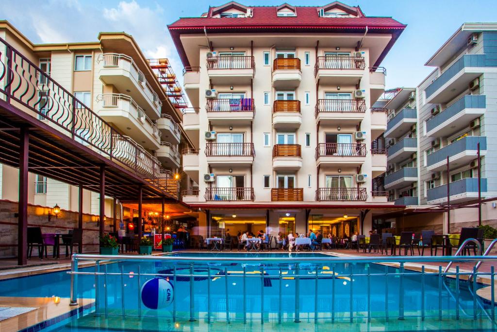 un hotel con piscina frente a un edificio en Oba Time Hotel, en Alanya