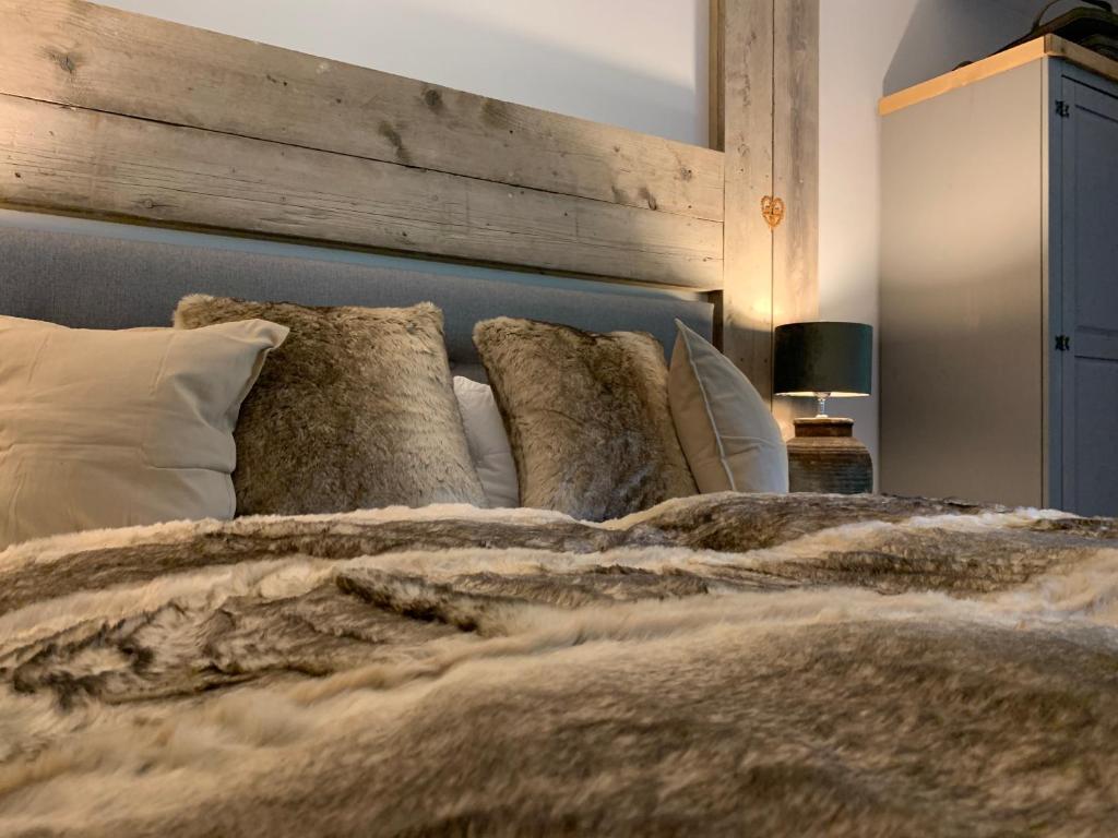 um quarto com uma cama grande e uma cabeceira em madeira em ferienapartment hahnenklee Apart.3 em Hahnenklee-Bockswiese
