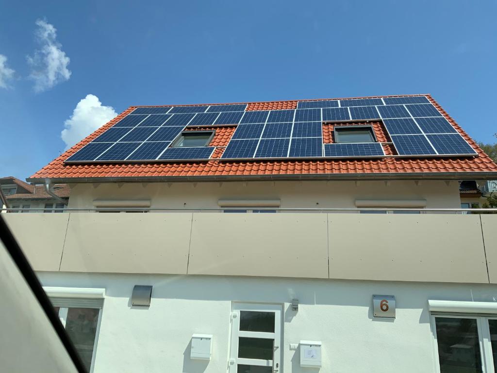 a building with solar panels on the roof at Kevins Ferienwohnungen Uhldingen-Mühlhofen in Uhldingen-Mühlhofen