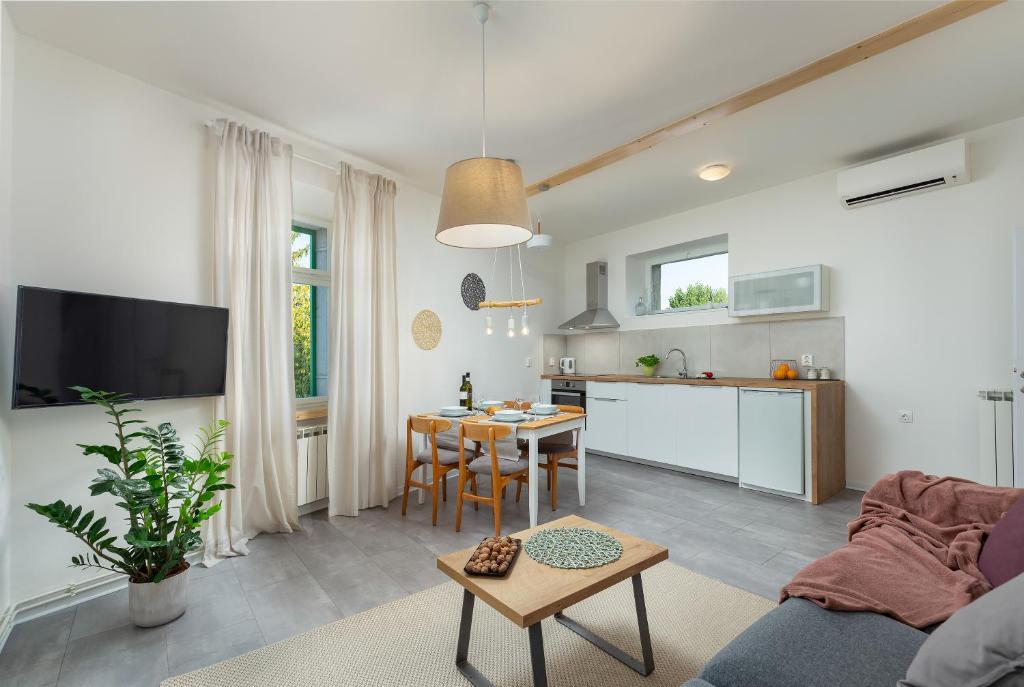 a living room with a table and a kitchen at Casa dei Nonni - in the center of Istria in Pazin