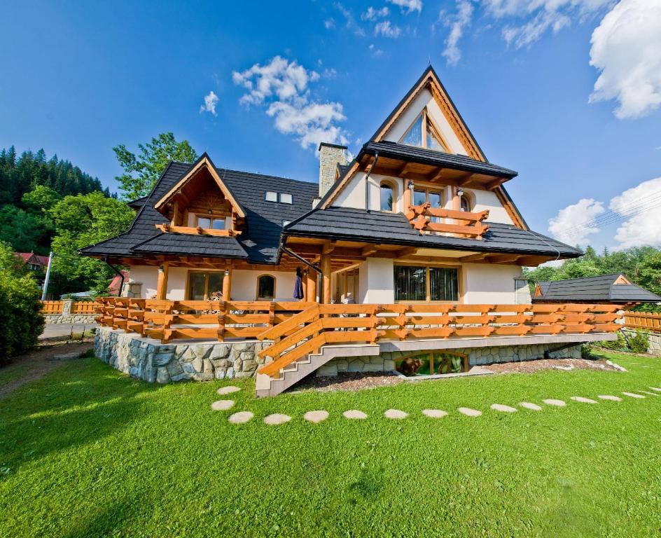 una gran casa de madera con un patio de césped en Leśny Dworek Zakopane en Zakopane