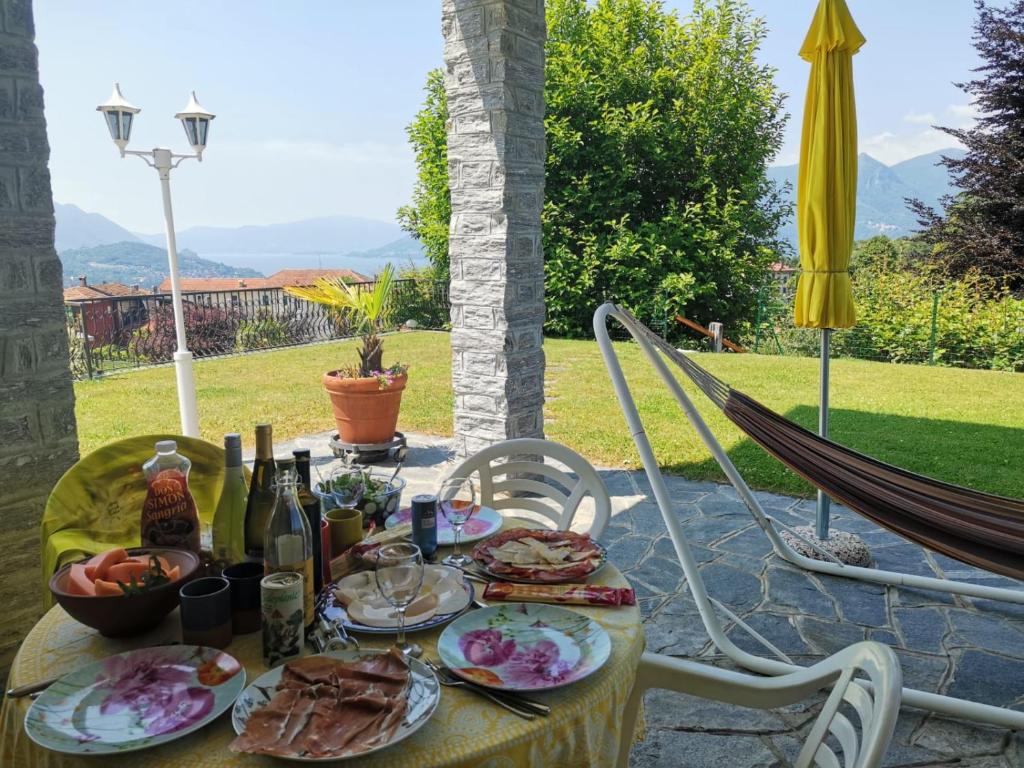 einen Tisch mit Teller mit Lebensmitteln und Flaschen Wein in der Unterkunft Bnbook Apartment La Motte in Luino