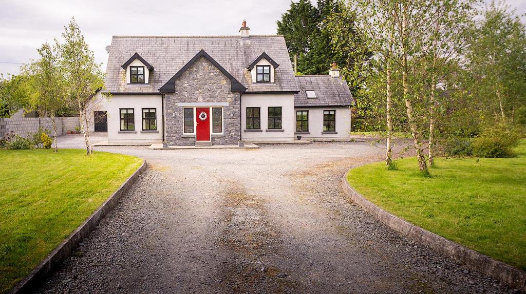 a house with a red door on a gravel driveway at The Calves Field in Carney