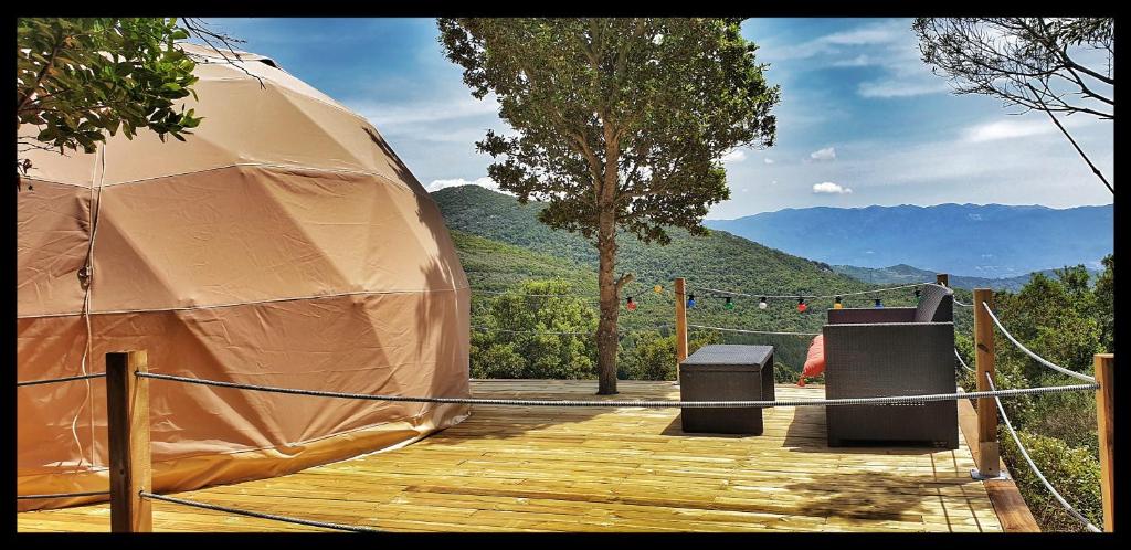a tent on a deck with a view of a mountain at Sottu E Stelle in Albitreccia